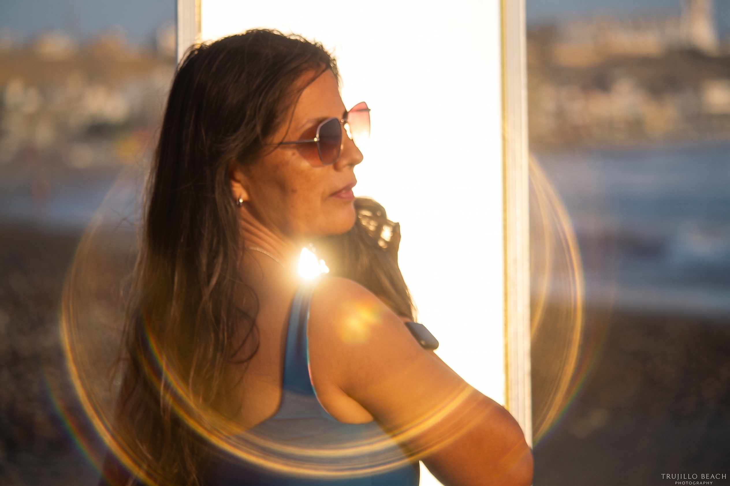 Sirena Solstice bodysuit, solid blue side, back and shoulder view at sunset