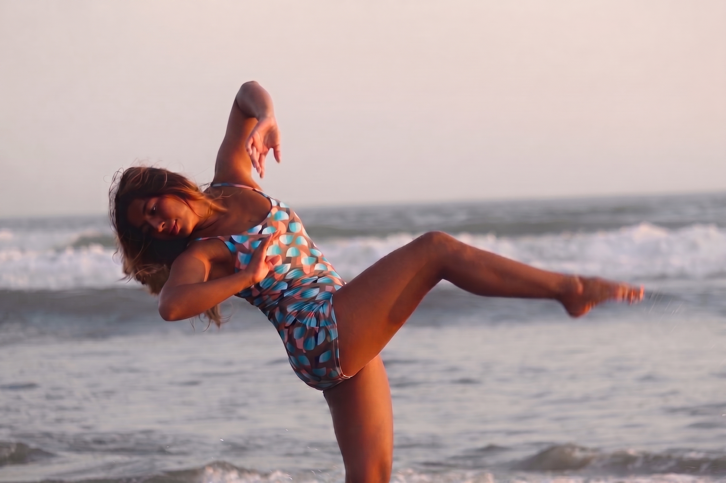 Sirena Solstice bodysuit, geometric print side, side view on the beach